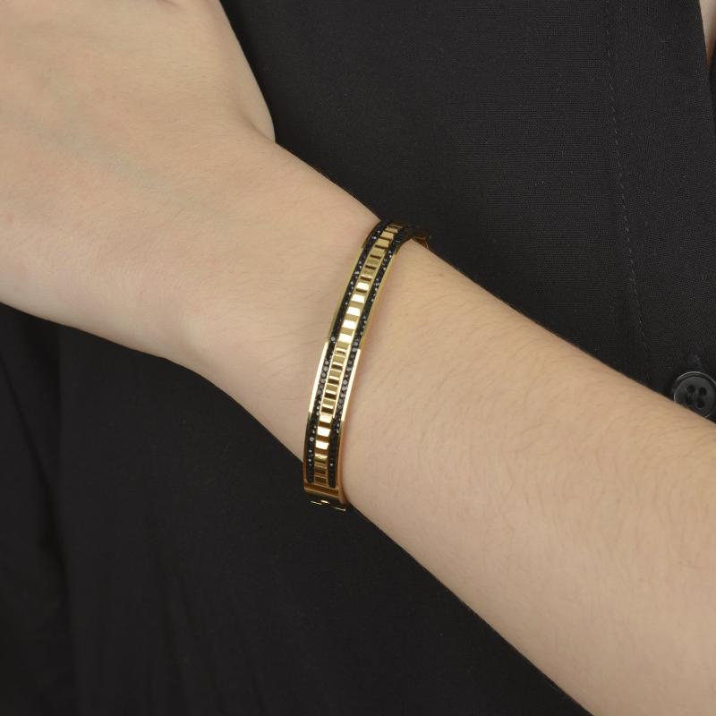 Χρυσό bangle βραχιόλι με μαύρες πέτρες και γεωμετρικό σχέδιο.

