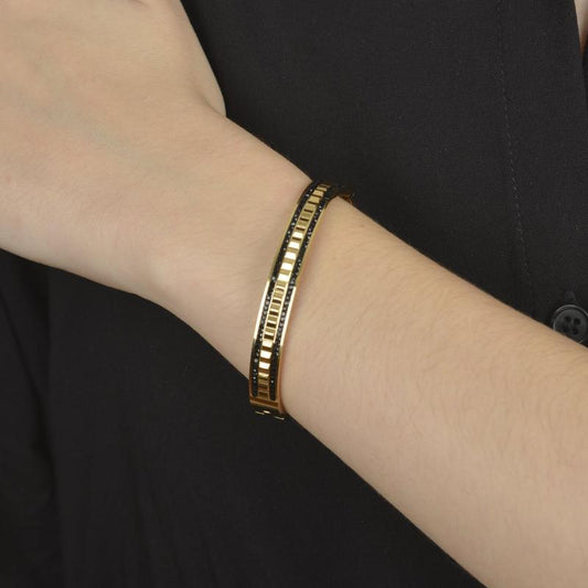 Χρυσό bangle βραχιόλι με μαύρες πέτρες και γεωμετρικό σχέδιο.

