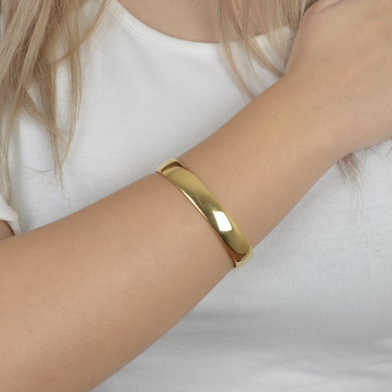Χρυσό minimal cuff βραχιόλι με γυαλιστερή επιφάνεια για εκλεπτυσμένες εμφανίσεις.

